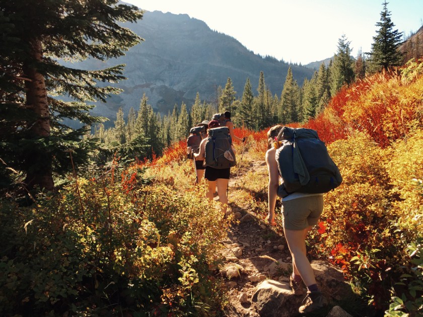 women backpacking through the Montana wilderness at the Wild Sage Summit