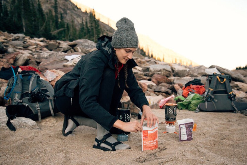 woman cooking backpacking meals